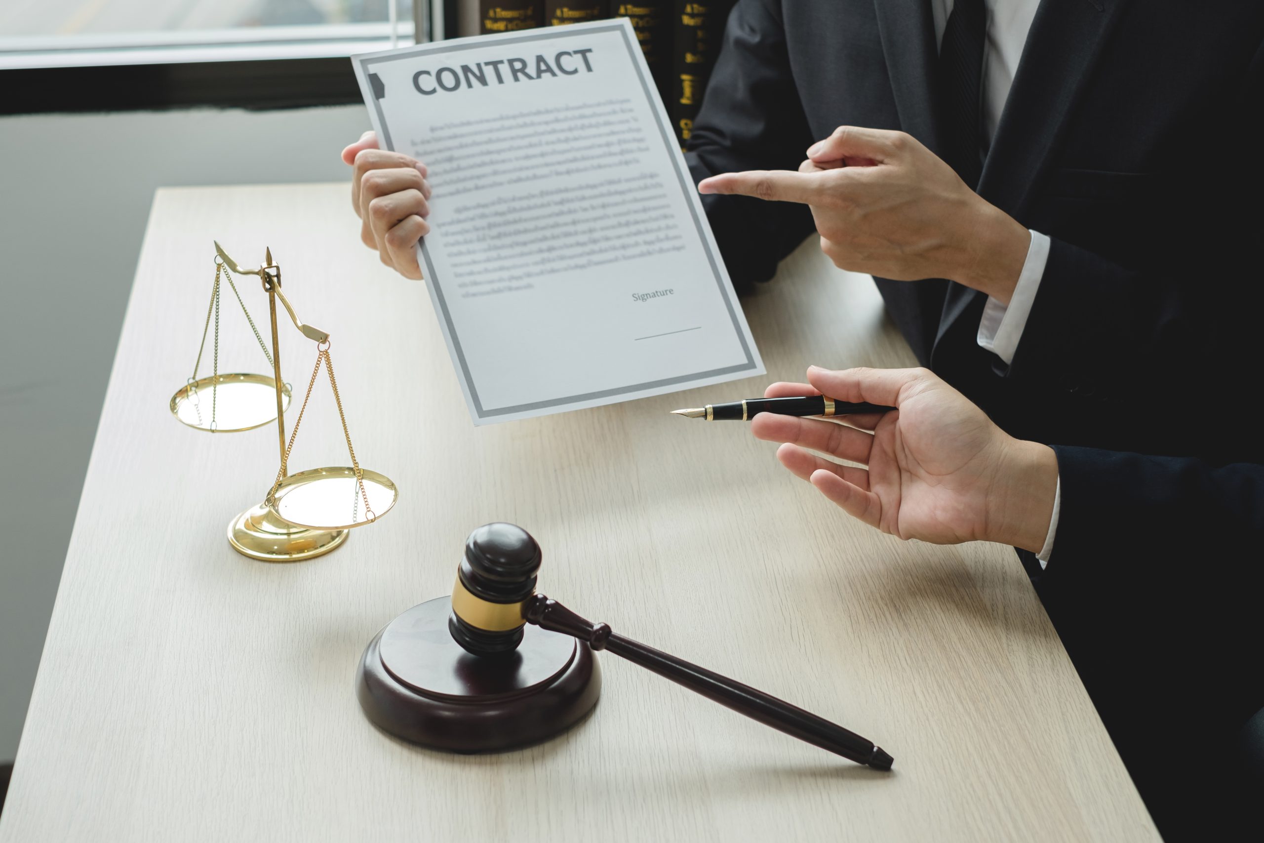 Male lawyers or a judge counseling clients about judicial justice and prosecution with scales, judges gavel, legal documents legal services concept.